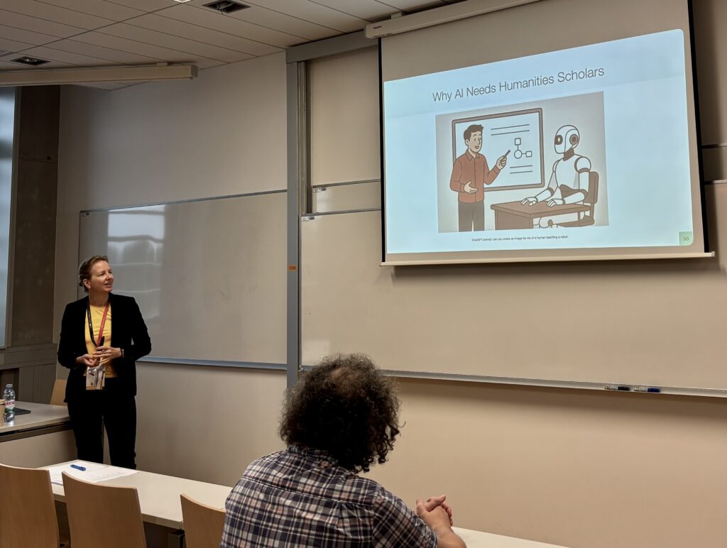 Woman standing in the classroom, presenting about why AI needs humanities scholars